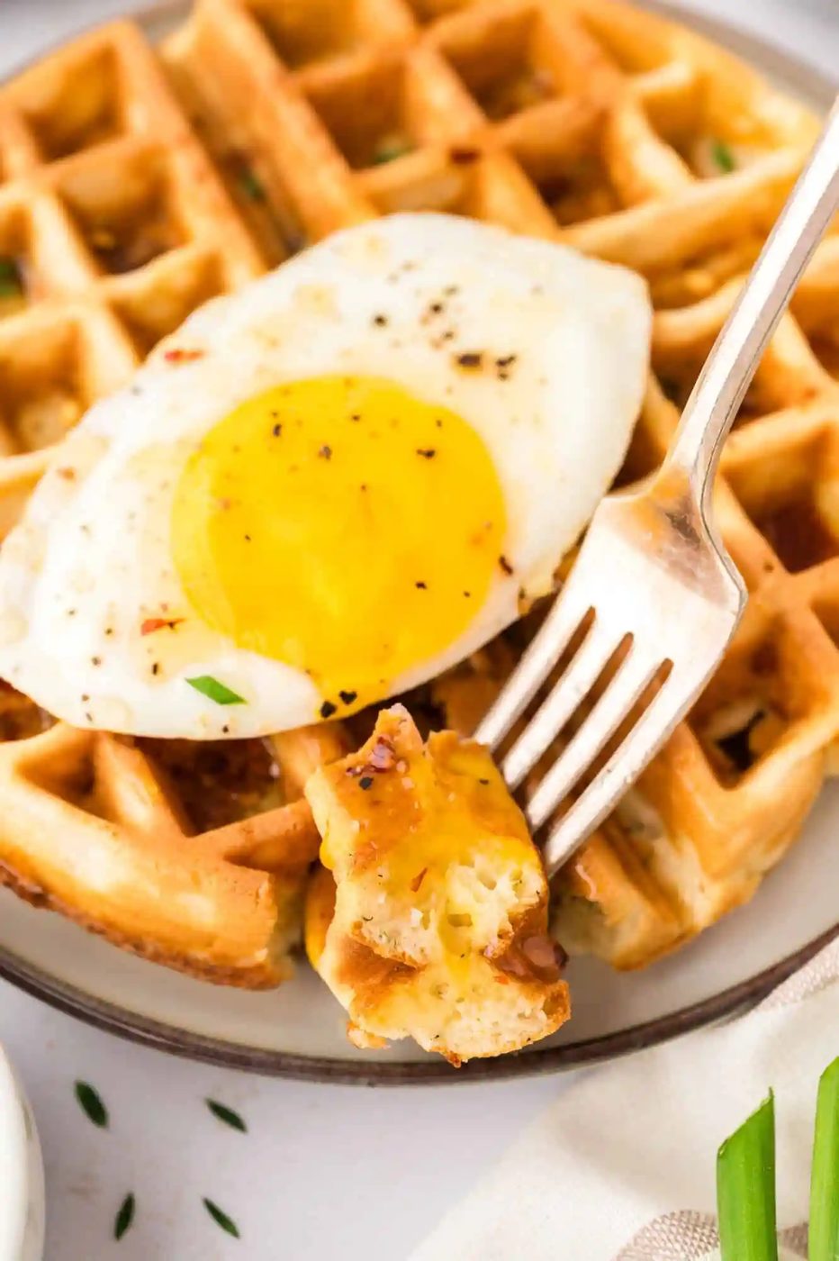 Close up of waffle, with part of it on a fork.
