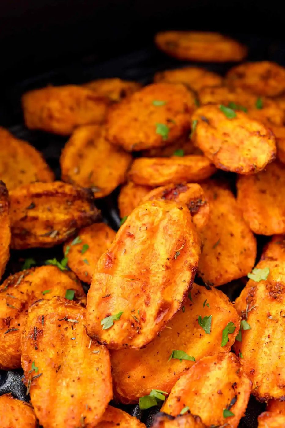 Sliced carrots, air fried and still in air fryer basket.
