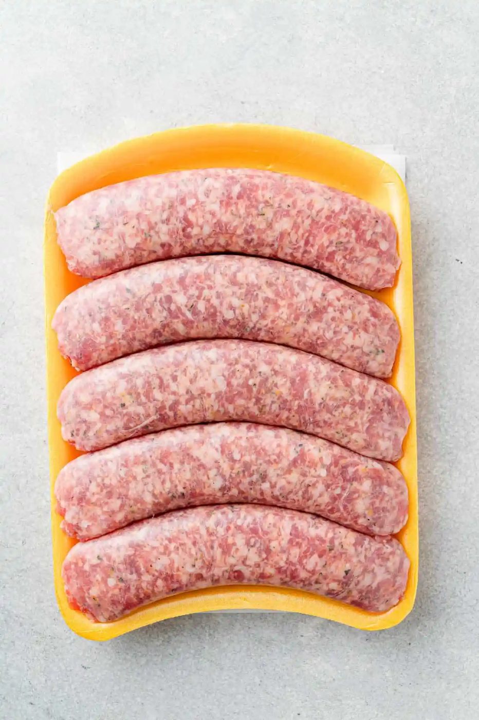 Uncooked Italian sausage in styrofoam package, plastic removed.