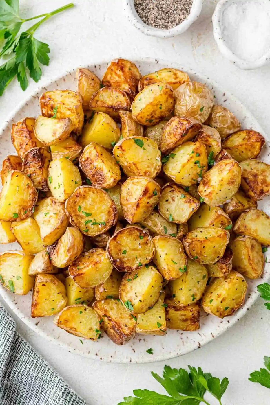Plated air fryer baby potatoes, with fresh parsley garnishing them.