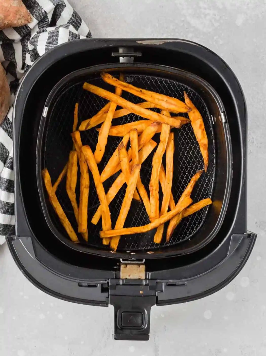 Overhead view of cooked sweet potato fries in an air fryer.