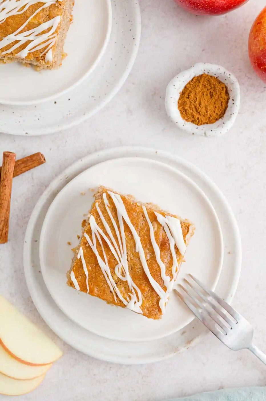 Overhead view of a slice of apple spice cake on a plate.