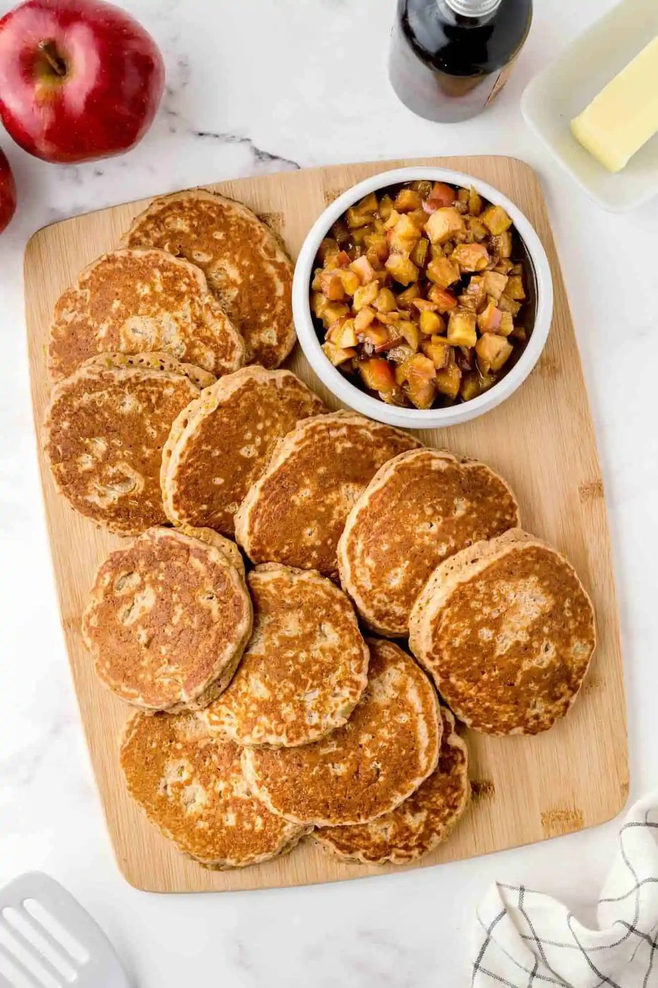 Apple quinoa pancakes on a wooden cutting board.