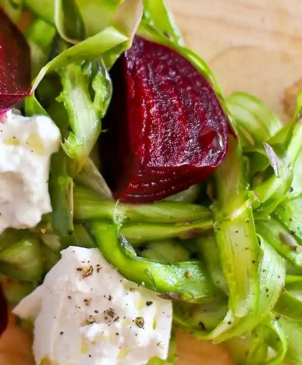 closeup of roasted beet, asparagus ribbons, and burrata.