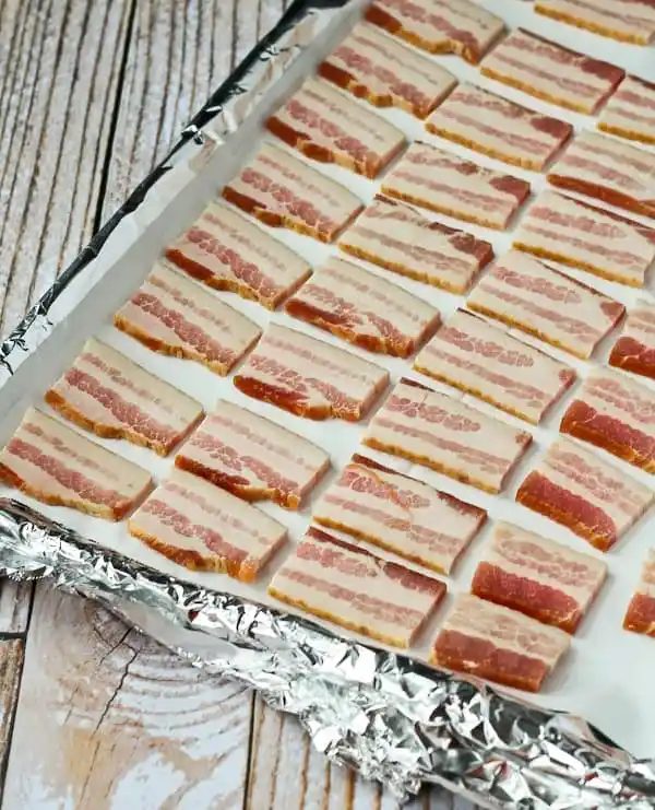 Sheet pan with uncooked bacon ready to bake.