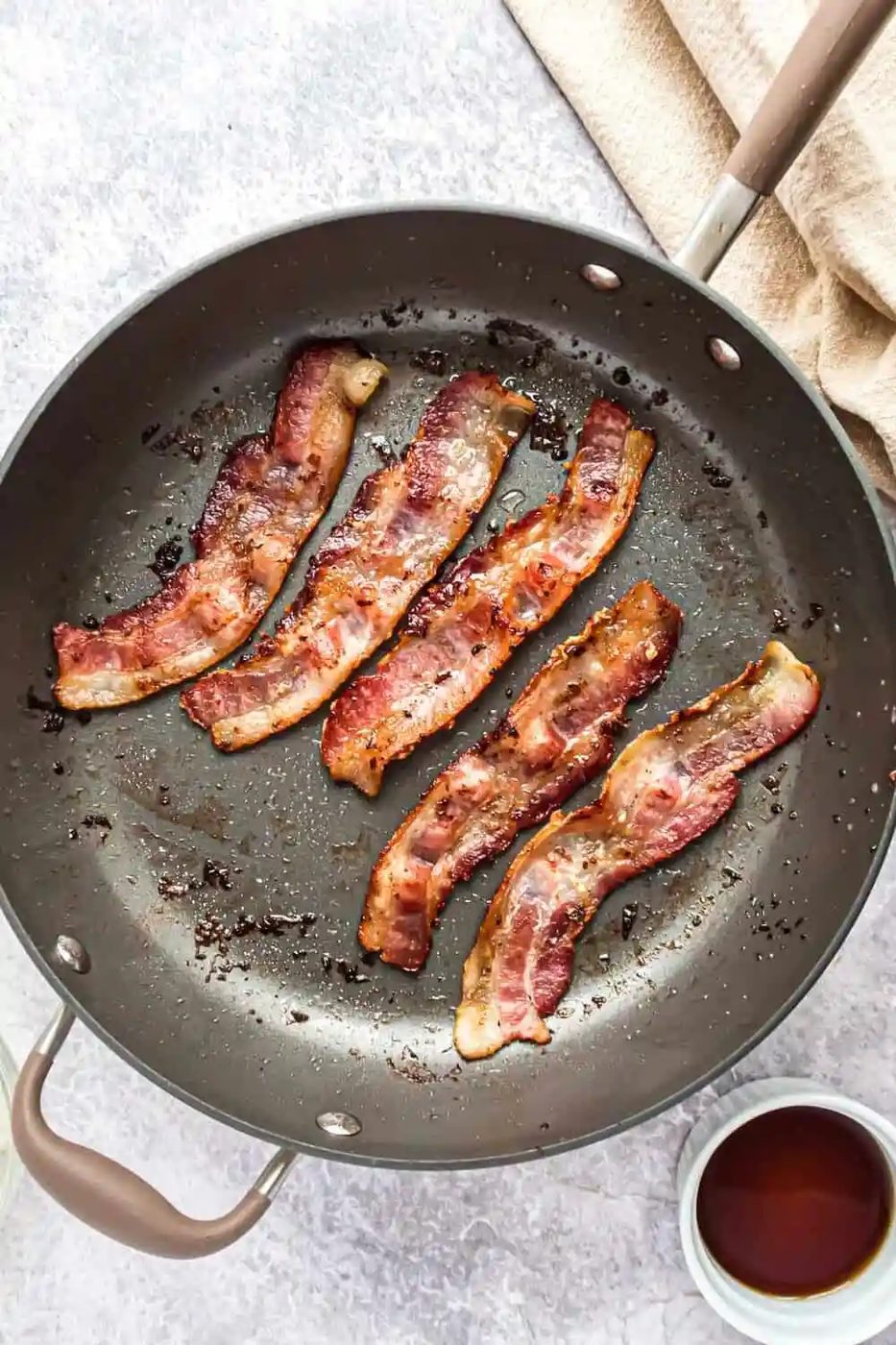 Bacon being cooked in frying pan.