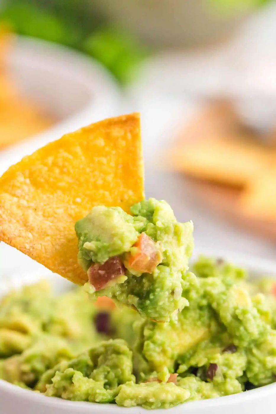 From-scratch tortilla chip being dipped in guacamole.