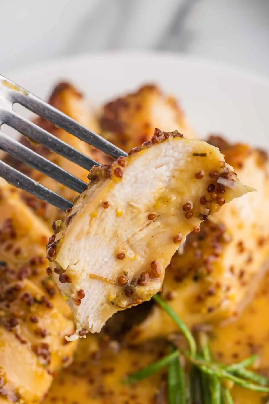 Close up of slice of chicken on a fork.