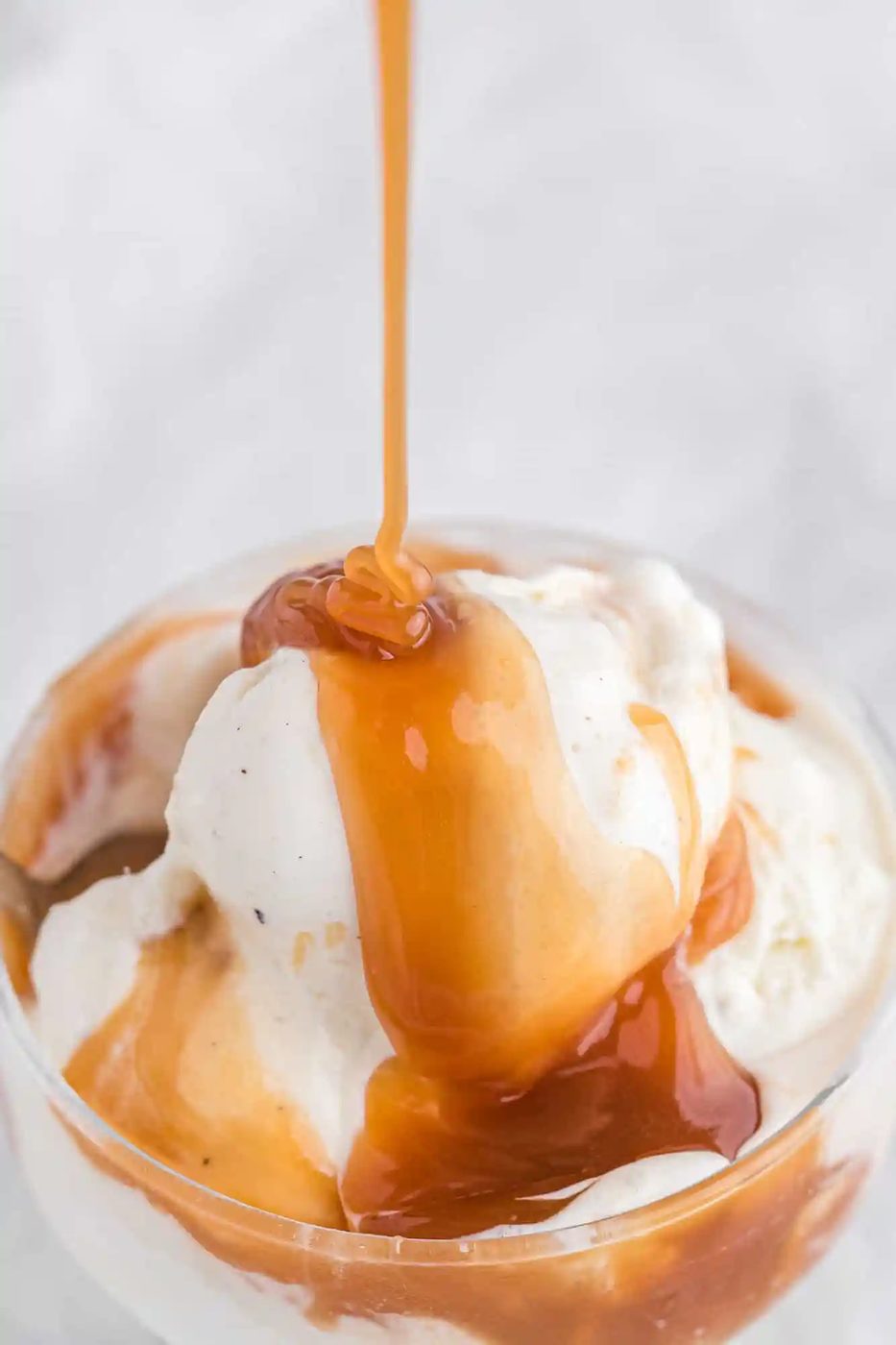 From-scratch caramel sauce being poured on ice cream.