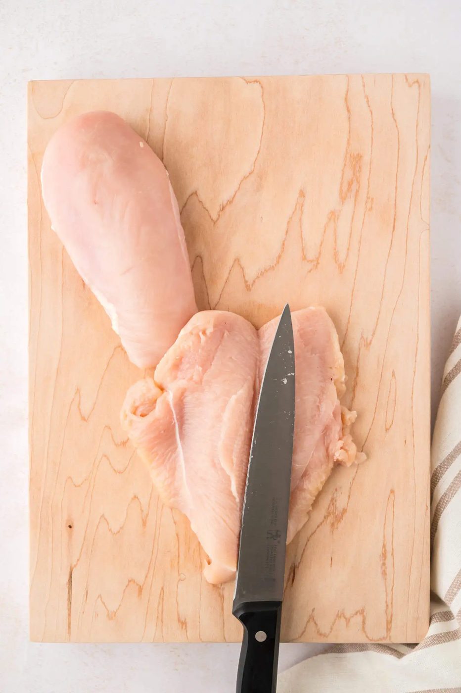 Chicken breast cut in half and opened like a butterfly.