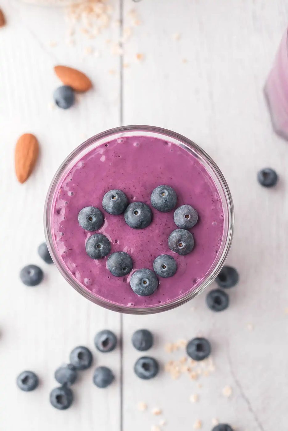 Overhead view of blueberry smoothie, topped with fresh blueberries.