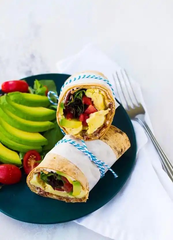 Picture of wrap on plate with garnishes and fork.