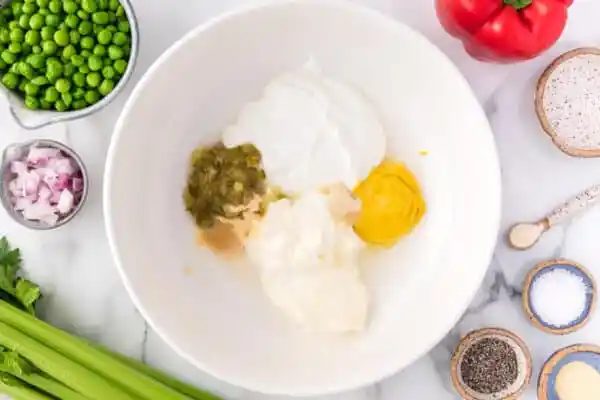 Macaroni salad dressing ingredients combined in a bowl.