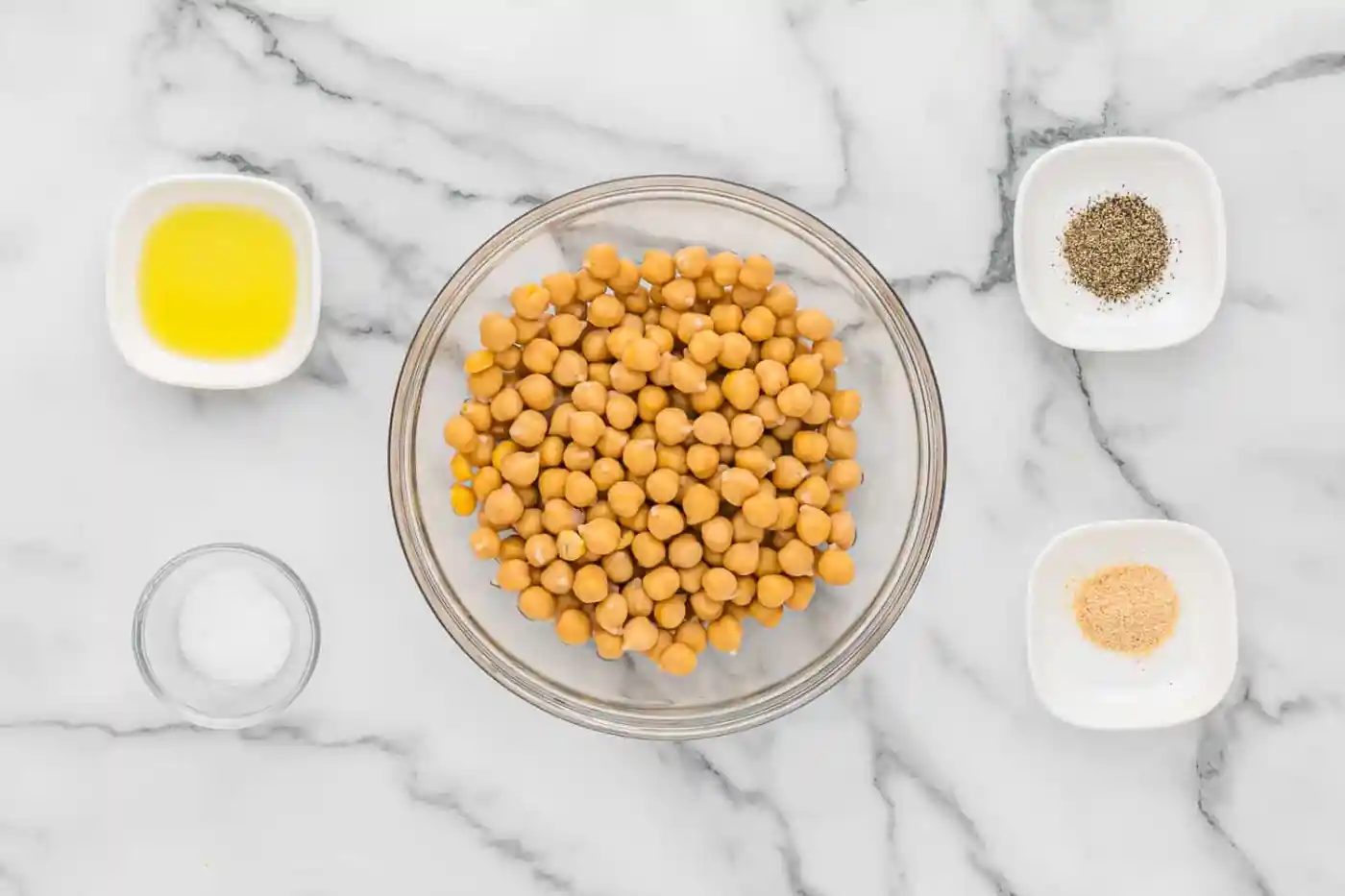 Overhead view of ingredients needed including chickpeas, olive oil, salt, and pepper.