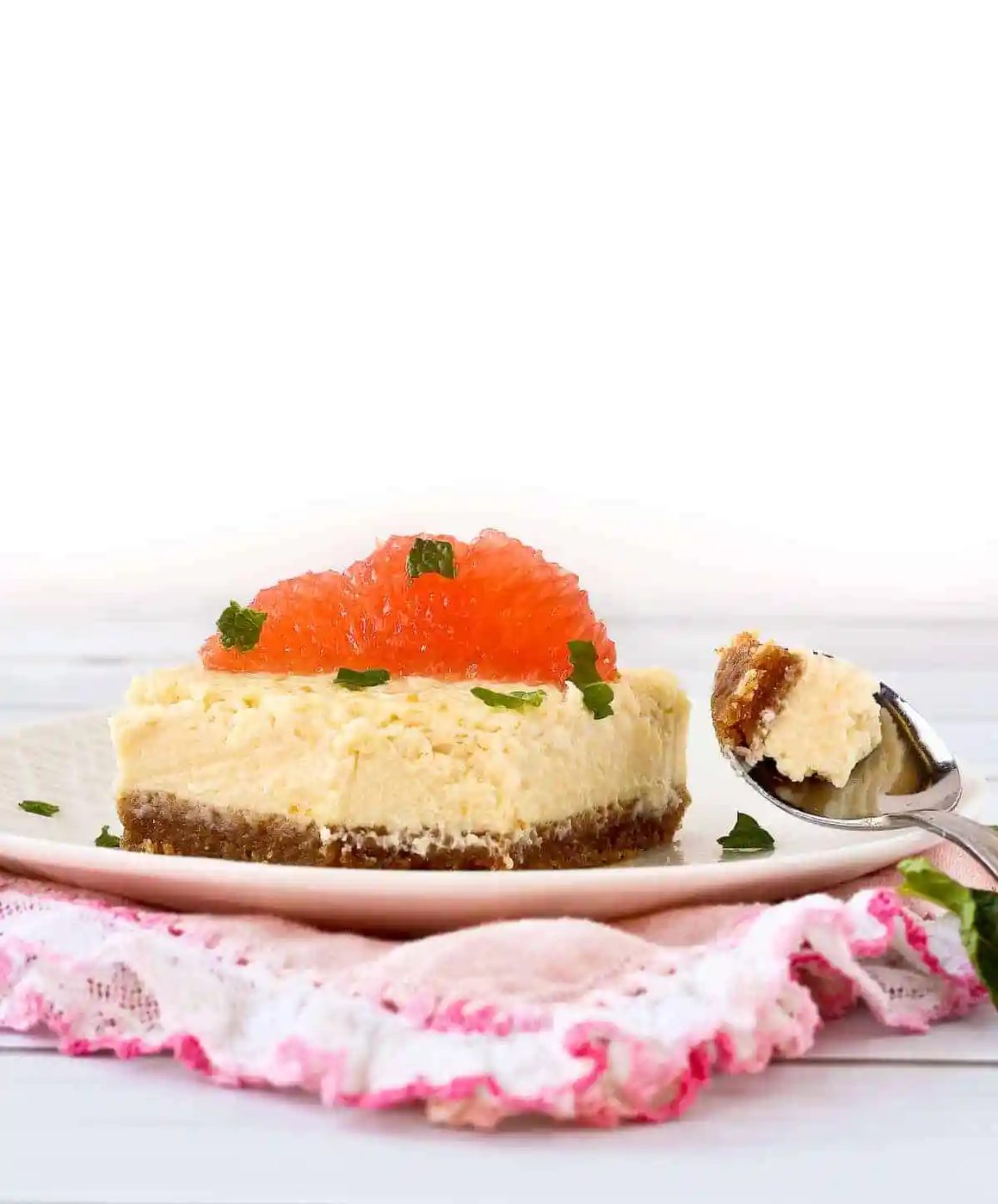 Grapefruit cheesecake square with a bite taken out of it.