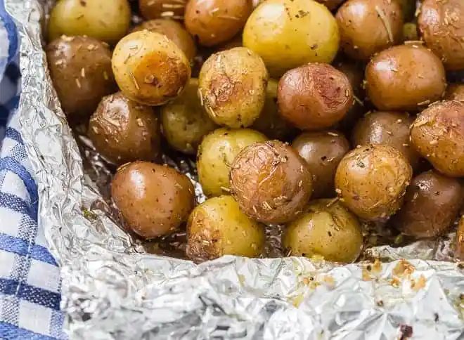 Landscape image of potatoes that have been grilled in a foil pack with rosemary.