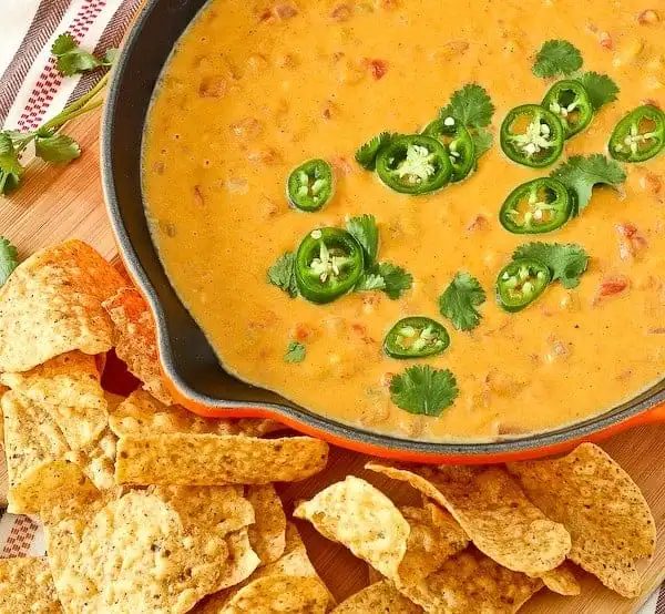 Orange queso dip topped with jalapeño slices.
