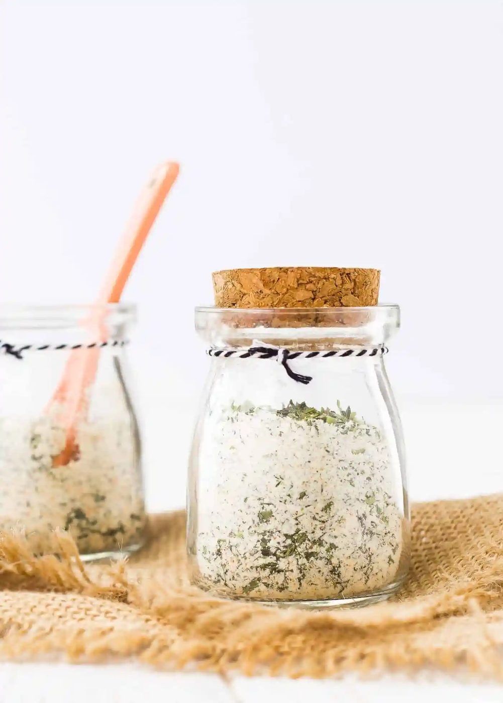 Buttermilk ranch seasoning mix in a small jar, more in the background.