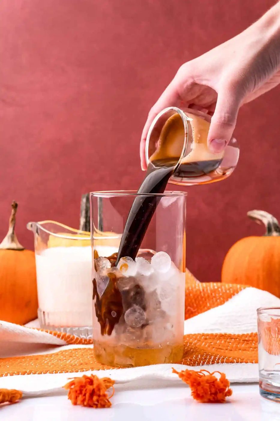 Espresso being added to ice in glass.