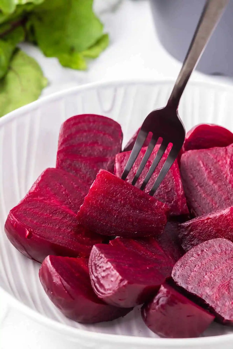 Instant pot beets, cut into chunks, one on a fork.