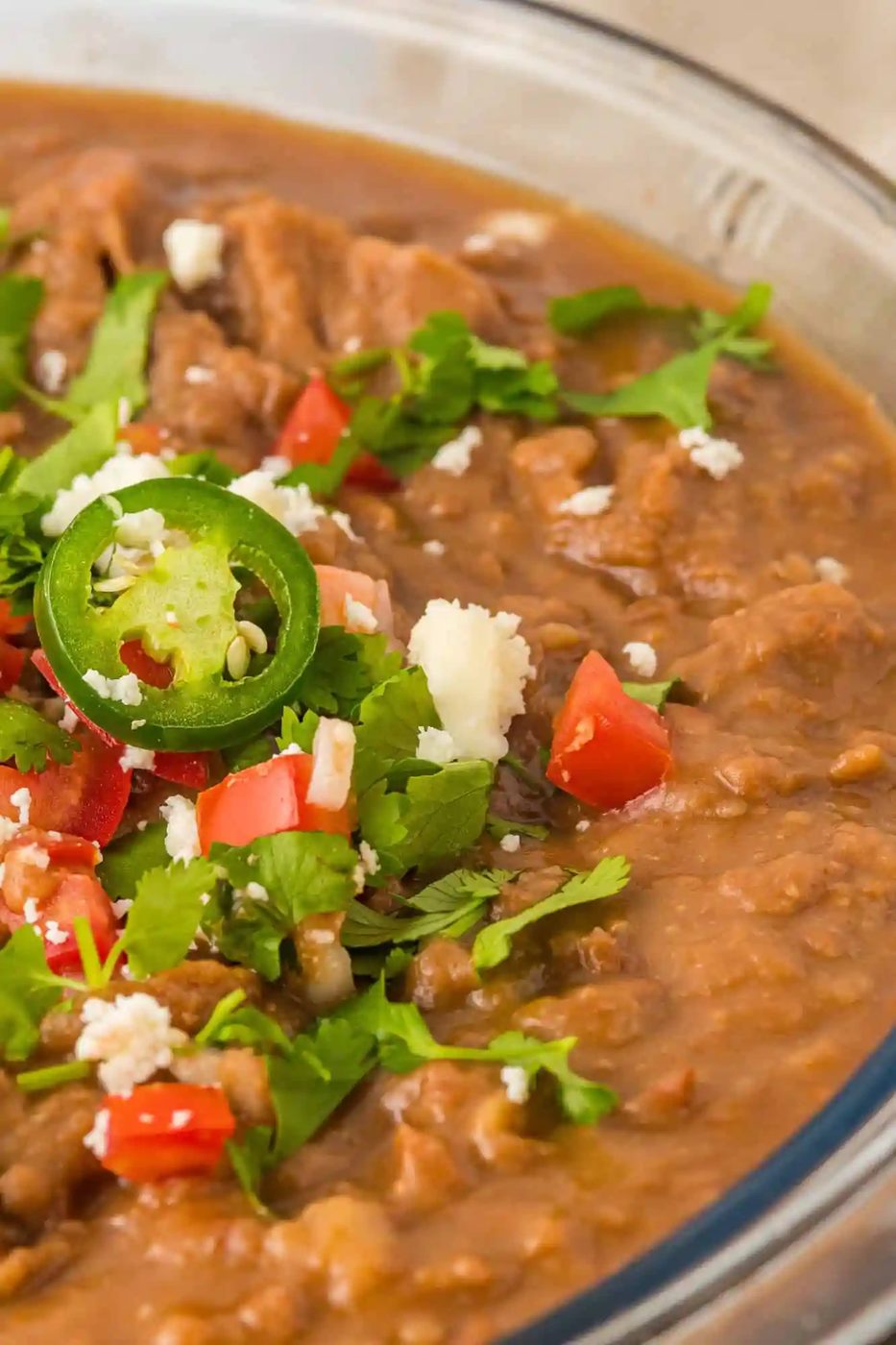 Beans topped with cheese, jalapeño, cilantro, and tomato.
