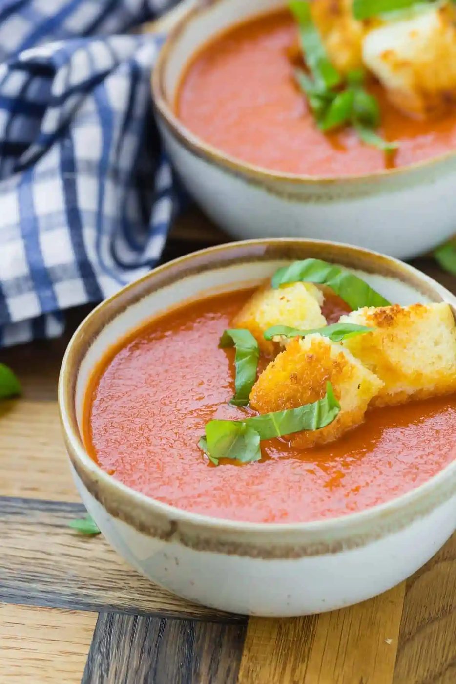Close up of creamy tomato soup in a bowl, topped with from-scratch croutons.