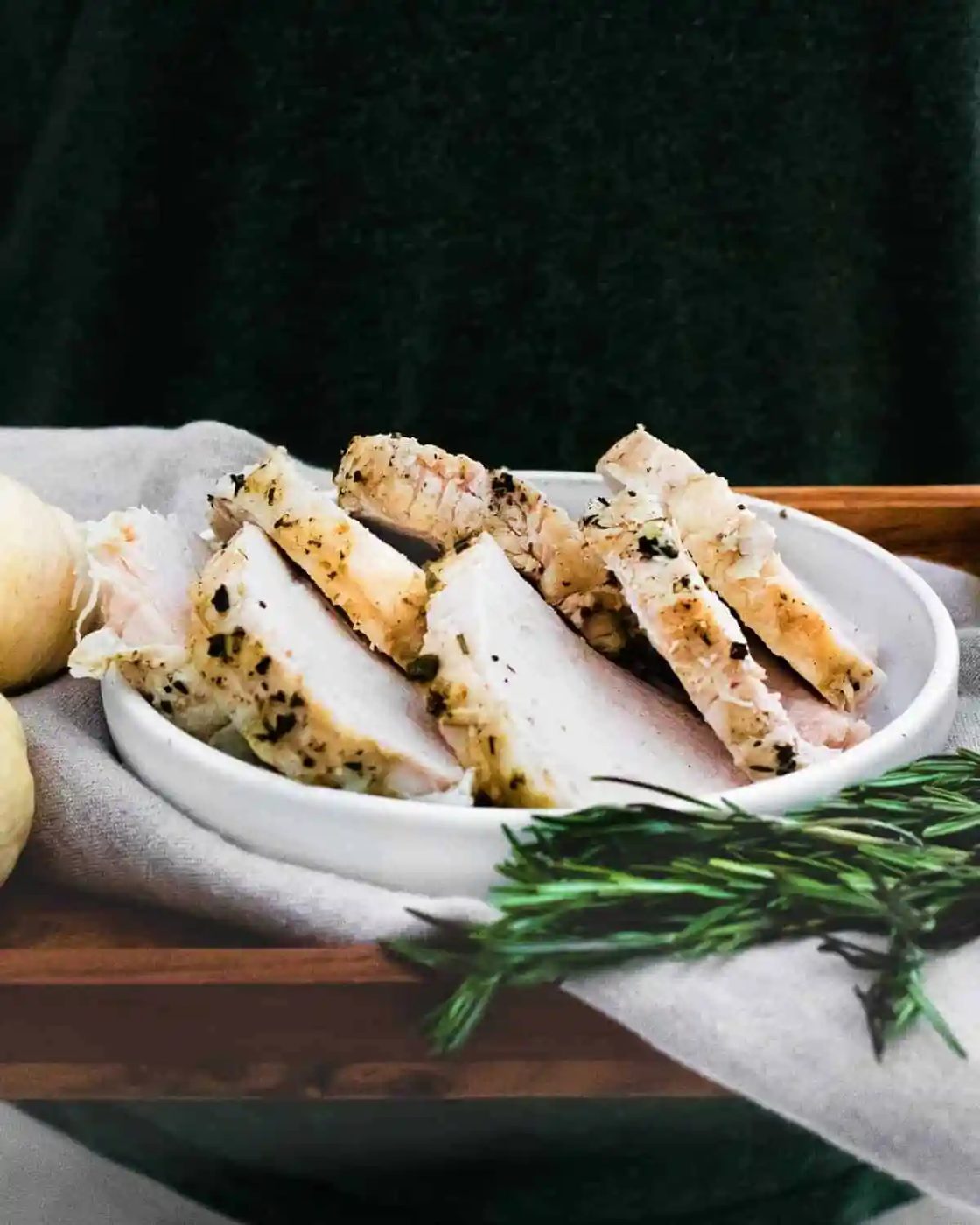 Slices of turkey on a platter, black background.