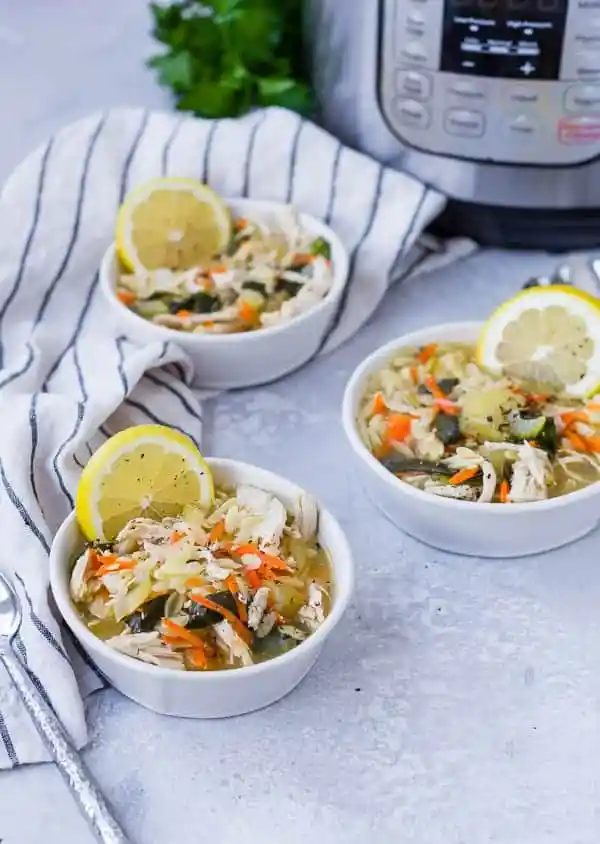 three bowls of soup with lemon silce, instant pot in background