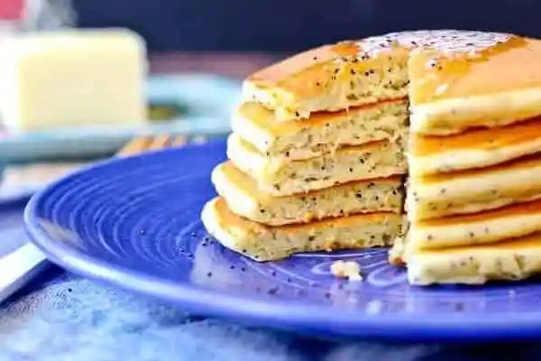Closeup of a stack of pancakes on blue plate.