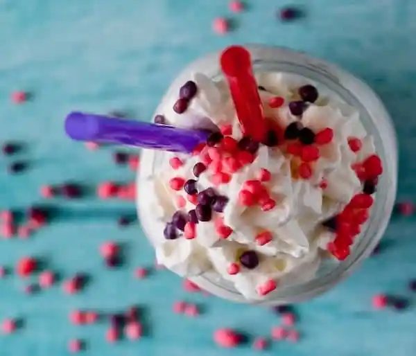Overhead view of Nerds milkshake with two straws.