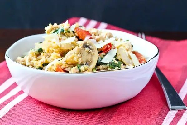 Serving of quinoa with ground turkey, kale, mushroom and tomatoes.