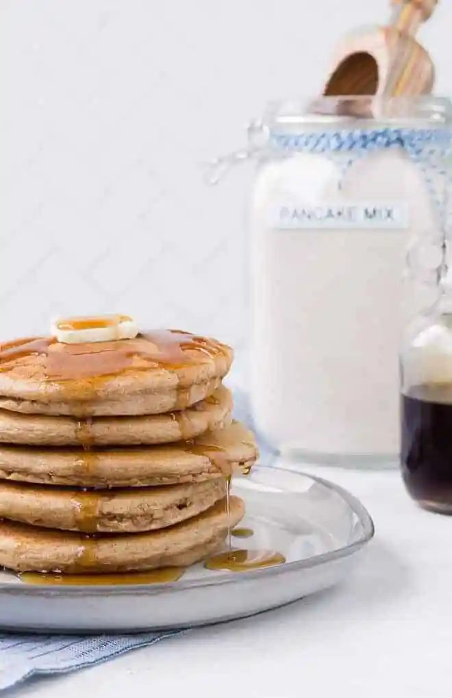 Image of a stack of pancakes with from-scratch pancake mix in the background.