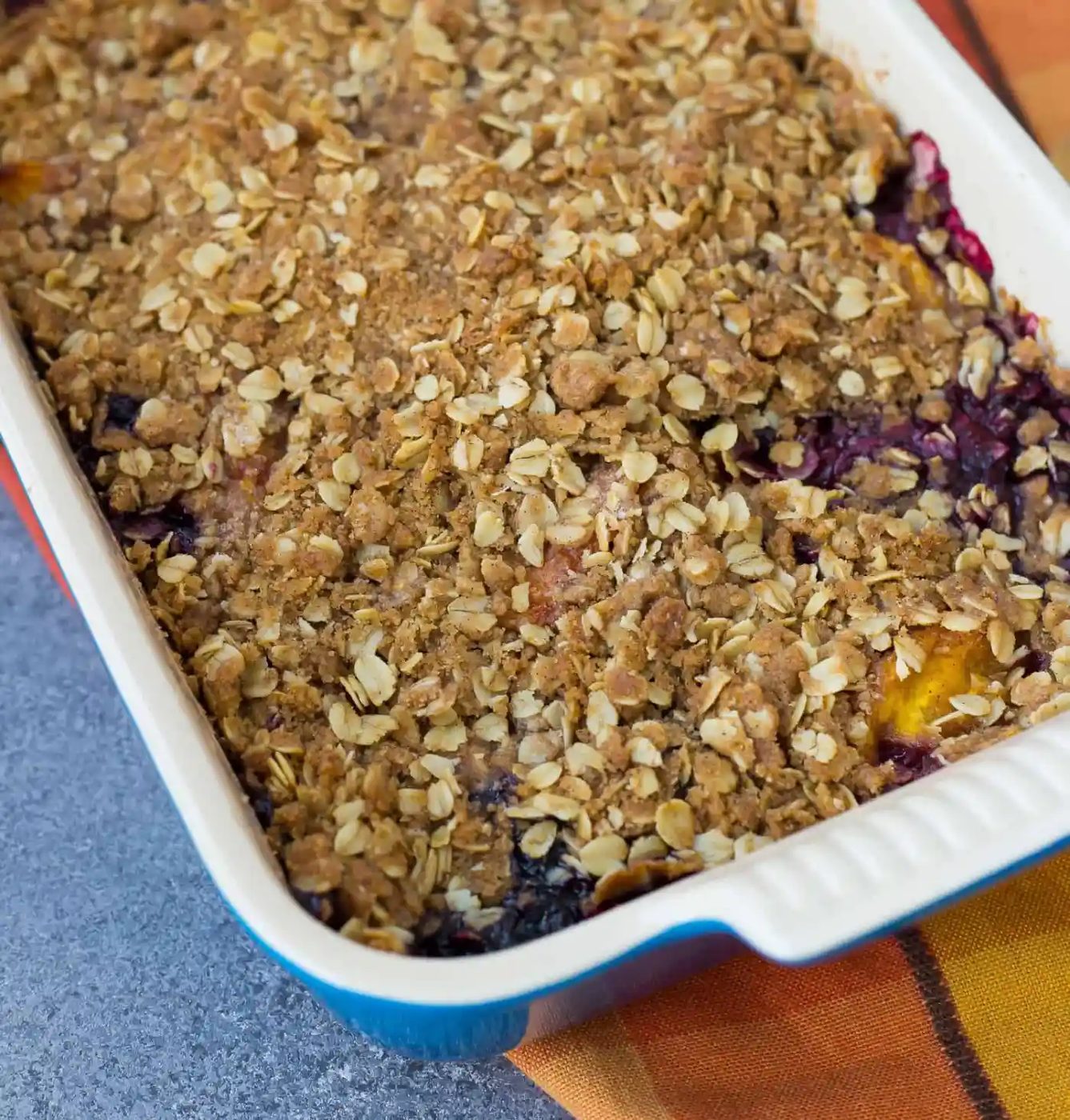 Peach blueberry crisp with the topping intact, no scoops removed.