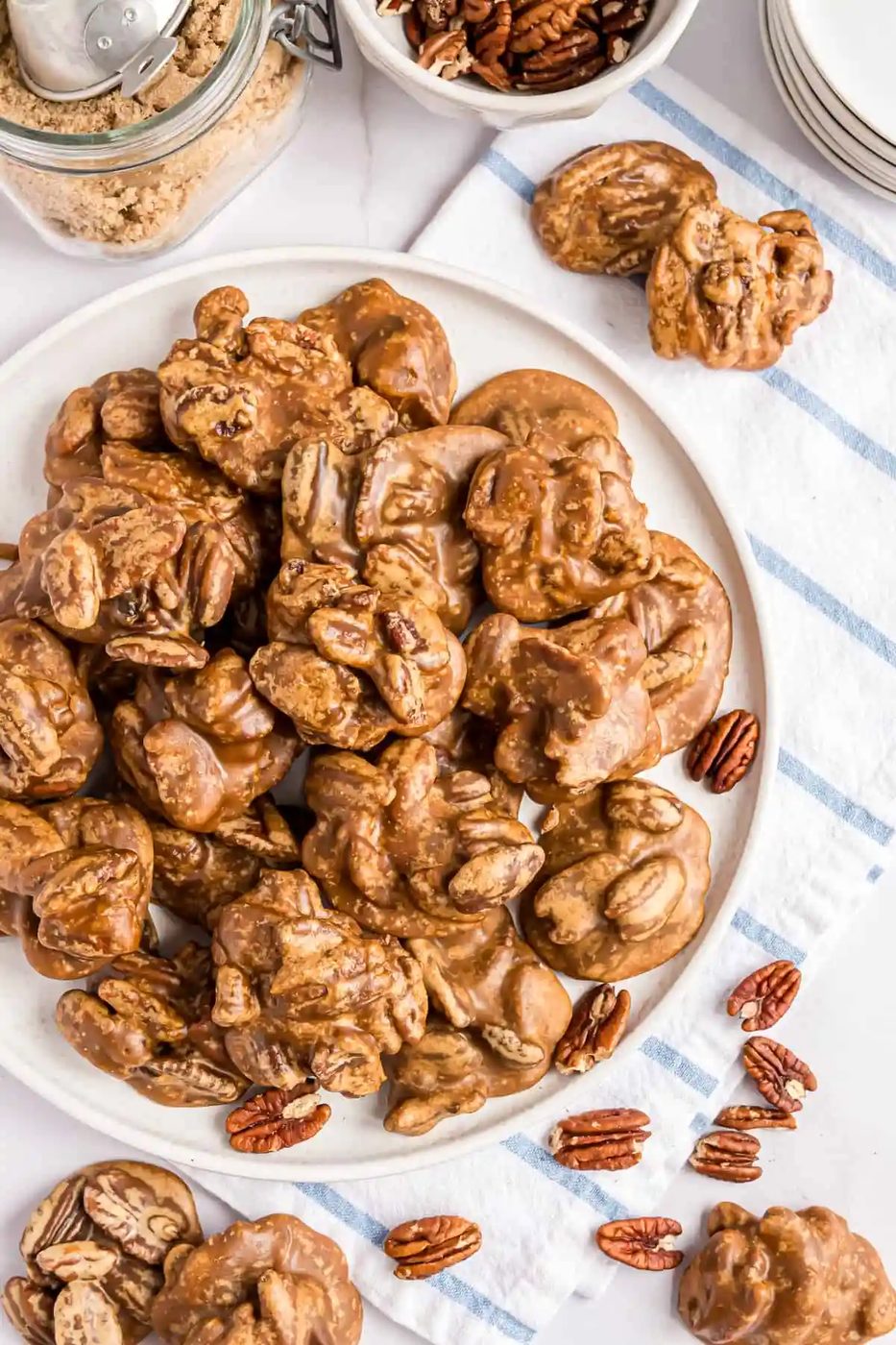 Pecan pralines piled up on a white platter.