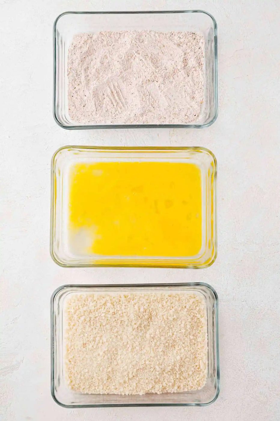 Three breading stations in rectangular glass dishes.