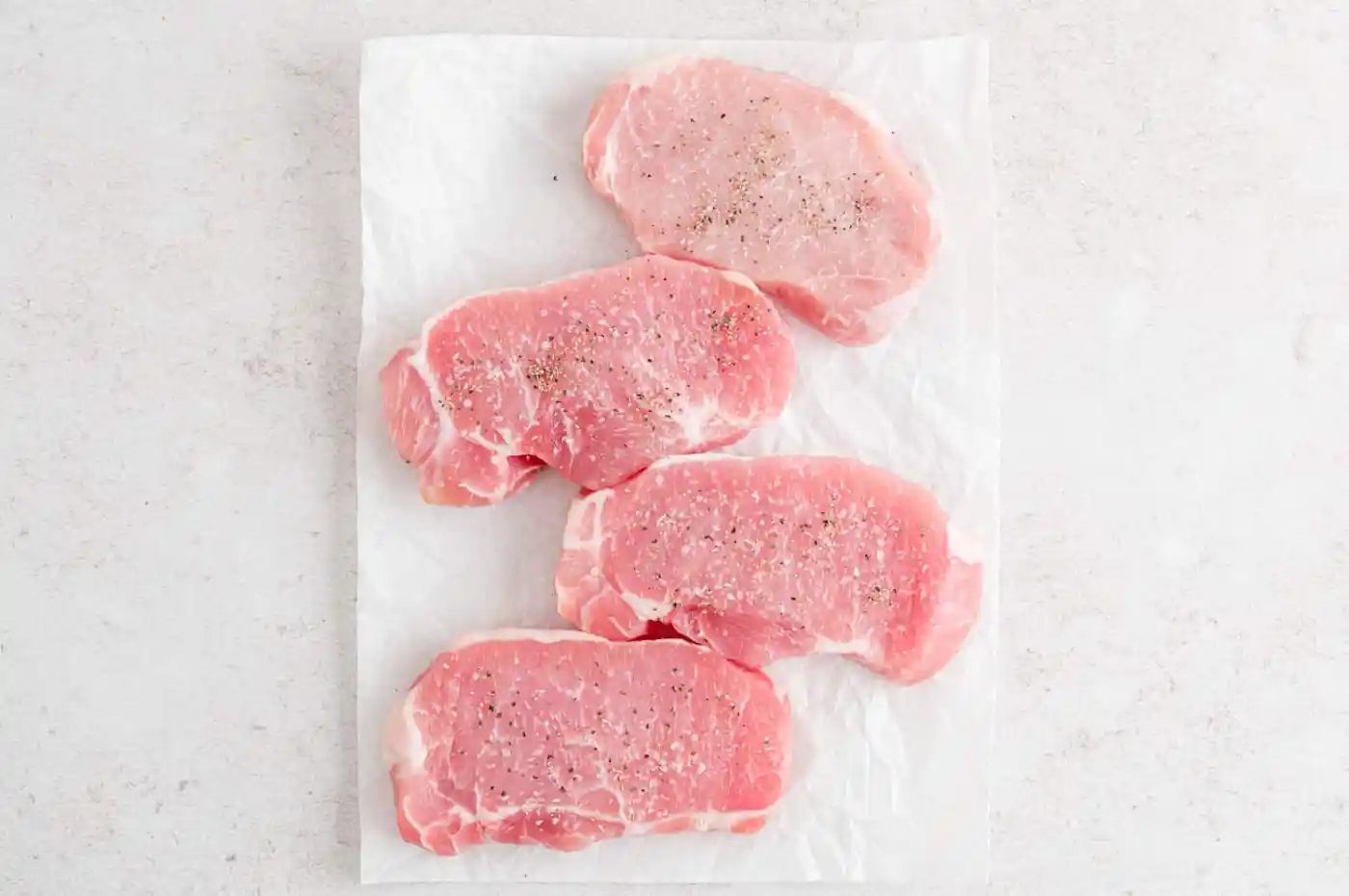 Pork chops seasoned with salt and pepper.