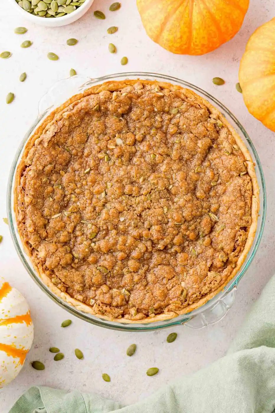 Overhead view of entire unsliced pumpkin pie, with streusel topping.