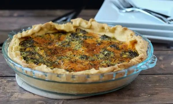 Quiche in a clear glass pie pan.