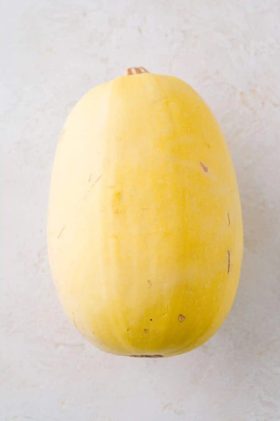Spaghetti squash, whole, on a white background.