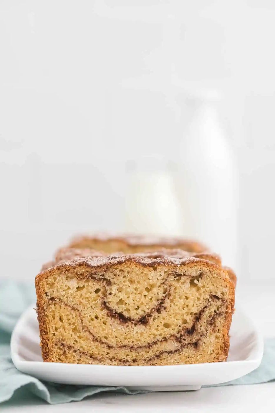 Shot of sliced loaf of speedy bread with a glass bottle of milk in the background.