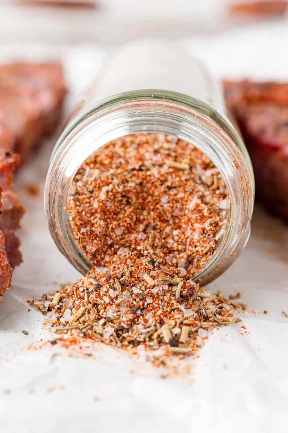 Steak seasoning spilling out of a jar.