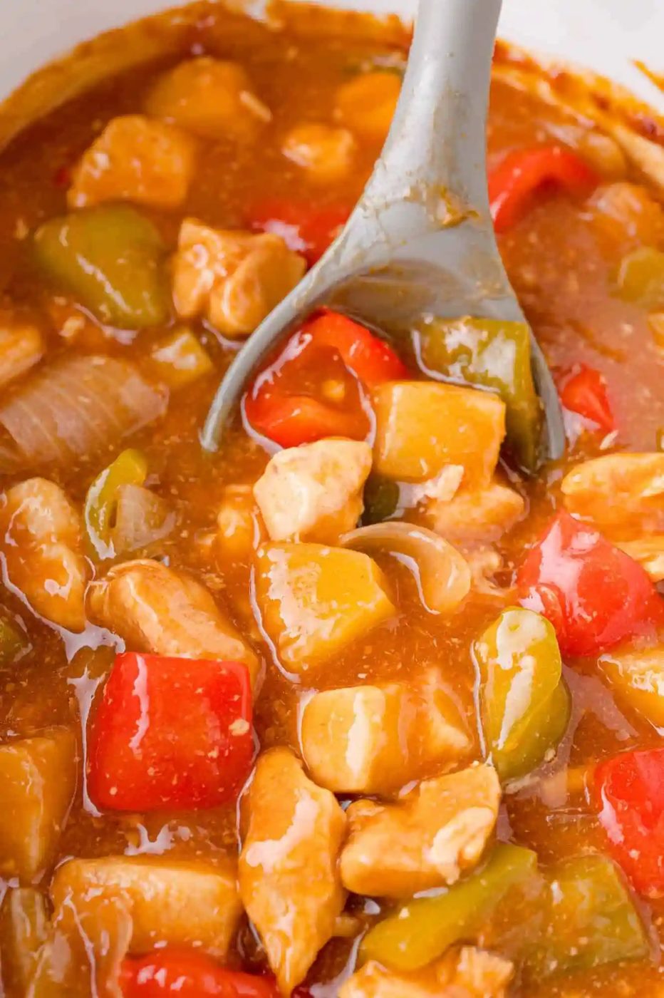Close-up of chicken, red and green peppers, and onions in a rich brown sauce.