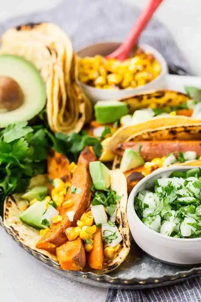 Beer marinated roasted sweet potatoes, charred corn, creamy avocado, crisp onions, and fresh cilantro, wrapped in a soft corn tortilla, make these vegetarian sweet potato tacos a taste sensation!