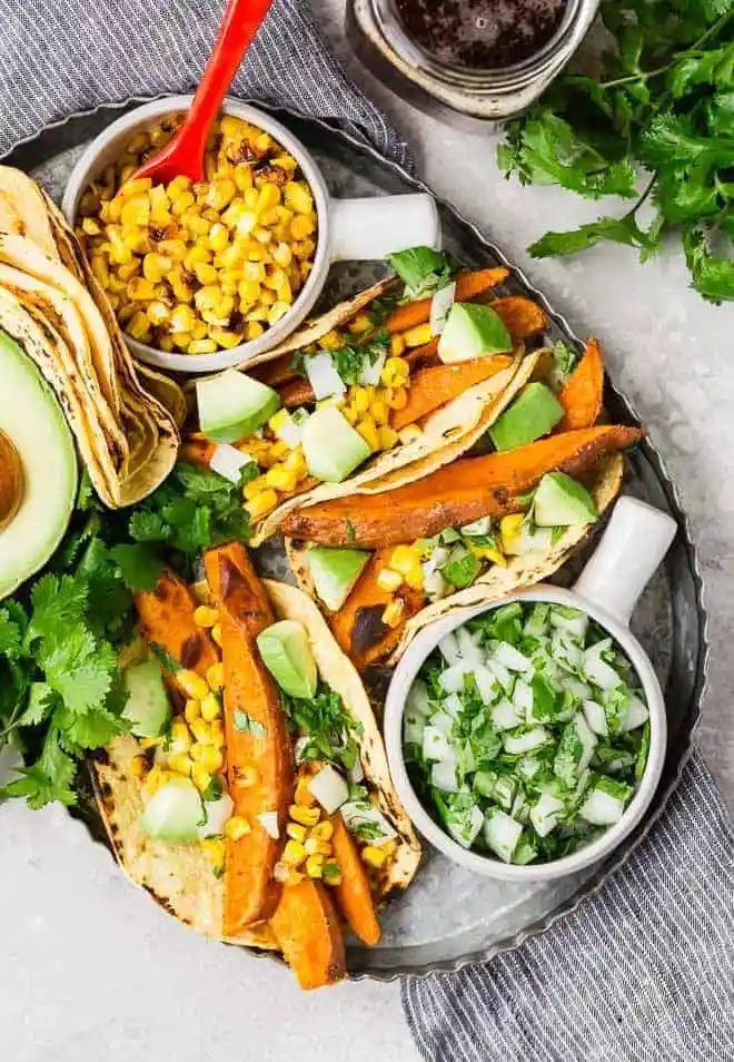 Beer marinated roasted sweet potatoes, charred corn, creamy avocado, crisp onions, and fresh cilantro, wrapped in a soft corn tortilla, make these vegetarian sweet potato tacos a taste sensation!