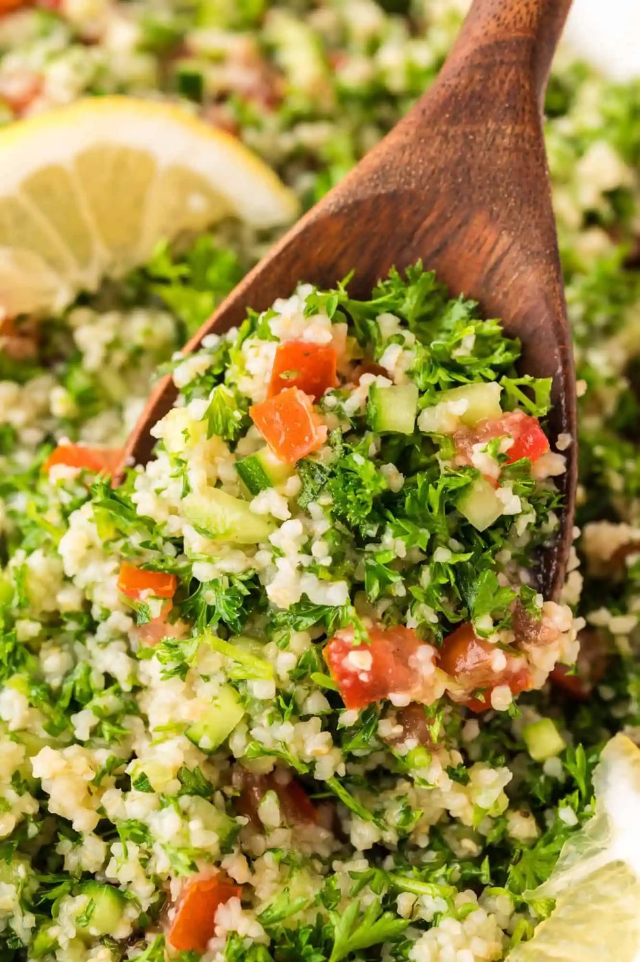 Close up image of tabbouleh on a large wooden serving spoon.