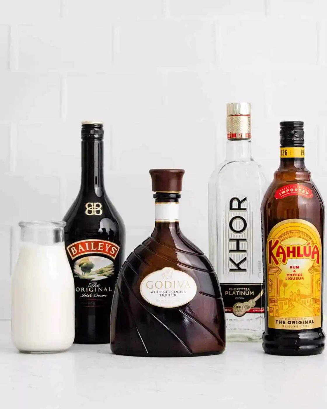Bottles in a row - milk, bailey's, white chocolate liqueur, vodka, kahlua.