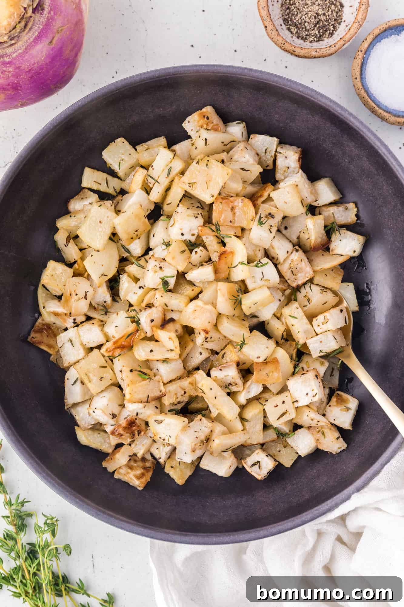 Roasted turnips presented in a large black serving bowl, ready for the table.