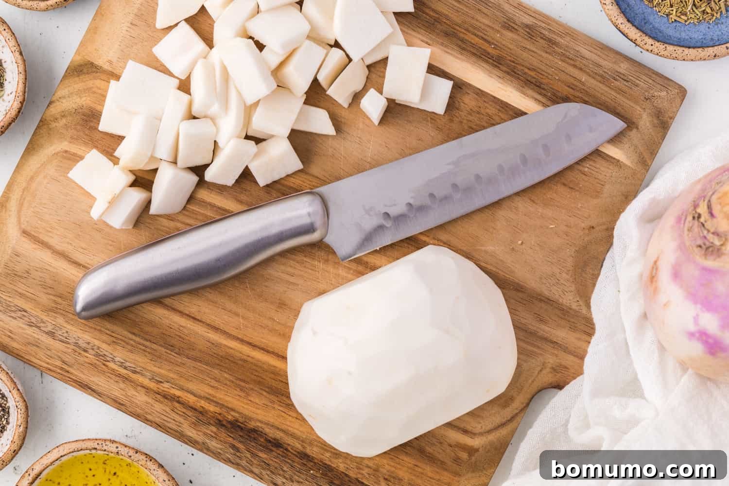 A turnip being precisely cut into small, bite-sized pieces on a cutting board.