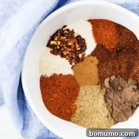 Overhead view of homemade chili spices in a white bowl.
