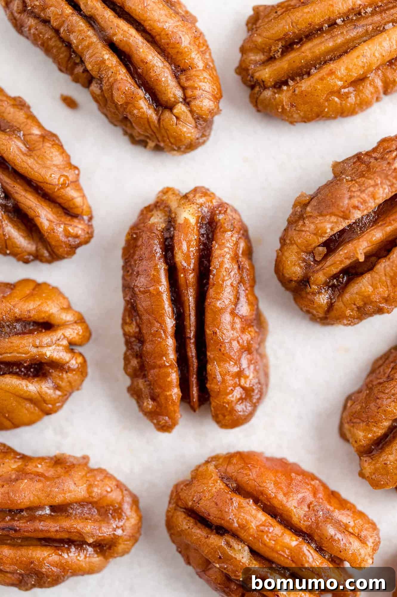 Best Spiced Pecans Ever 3 Pecans in a single layer on a white background. Perfect for snacking.